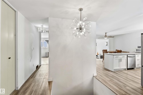 Hallway featuring light wood-style flooring and suspended lighting - 11615 150 Avenue, Edmonton, AB - Indoor