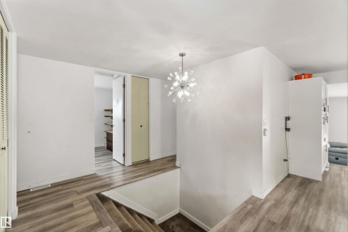 Hallway featuring wood finished floors and a chandelier - 11615 150 Avenue, Edmonton, AB - Indoor Photo Showing Other Room