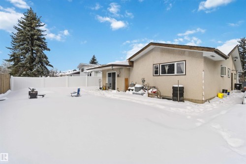 Snow covered back of property featuring stucco siding and a fenced backyard - 11615 150 Avenue, Edmonton, AB - Outdoor