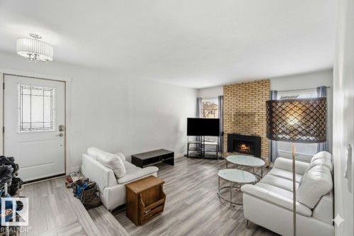 Living area featuring a fireplace and wood finished floors - 11615 150 Avenue, Edmonton, AB - Indoor With Fireplace