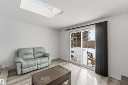 Living area featuring a skylight and light wood-type flooring - 11615 150 Avenue, Edmonton, AB - Indoor Photo Showing Living Room