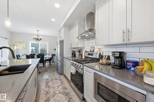 Kitchen with appliances with stainless steel finishes, hanging light fixtures, white cabinets, and recessed lighting - 7803 Yorke Road, Edmonton, AB - Indoor Photo Showing Kitchen With Double Sink With Upgraded Kitchen