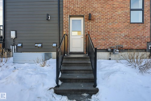 Snow covered property entrance featuring brick siding and crawl space - 7803 Yorke Road, Edmonton, AB - Outdoor With Exterior