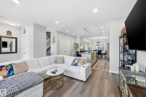 Living area featuring dark wood finished floors, recessed lighting, a chandelier, and stairway - 7803 Yorke Road, Edmonton, AB - Indoor Photo Showing Living Room