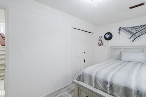 Bedroom with a textured ceiling, light wood-style flooring, and a closet - 236 Lago Lindo Crescent, Edmonton, AB 