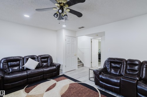 Living room featuring a textured ceiling, wood finished floors, recessed lighting, and a ceiling fan - 236 Lago Lindo Crescent, Edmonton, AB 