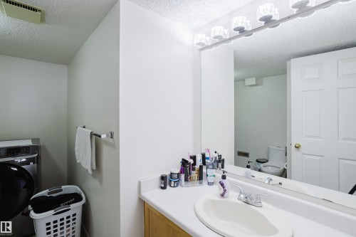 Bathroom with washer / clothes dryer, a textured ceiling, and vanity - 236 Lago Lindo Crescent, Edmonton, AB 