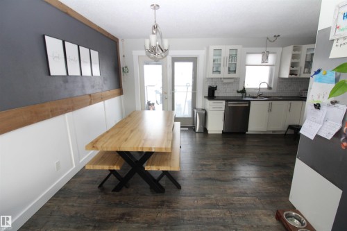 Dining area with dark wood-style floors and a chandelier - 10319 106 Ave, Westlock, AB - Indoor