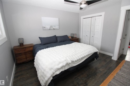 Bedroom with dark wood-style flooring, a closet, and ceiling fan - 10319 106 Ave, Westlock, AB - Indoor Photo Showing Bedroom