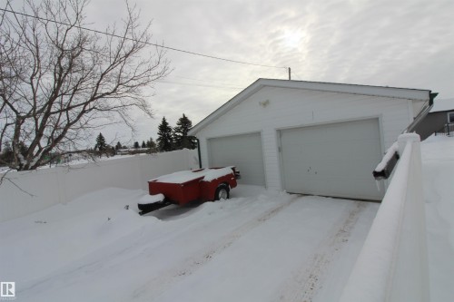 View of snow covered exterior with an outdoor structure and a detached garage - 10319 106 Ave, Westlock, AB - Outdoor