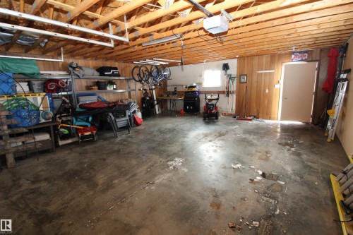 Garage with a garage door opener and wood walls - 10319 106 Ave, Westlock, AB - Indoor Photo Showing Garage