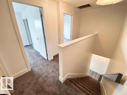 Stairway featuring carpet flooring and baseboards - 10 446 Allard Boulevard, Edmonton, AB - Indoor Photo Showing Other Room