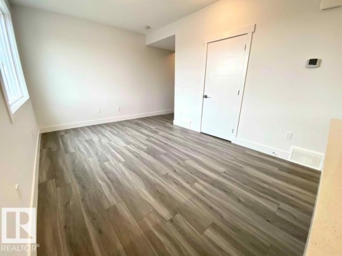 Unfurnished bedroom with light wood-style floors and baseboards - 10 446 Allard Boulevard, Edmonton, AB - Indoor Photo Showing Other Room