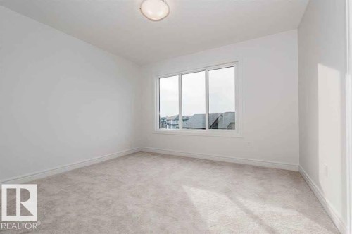 Unfurnished room with light carpet and baseboards - 10 446 Allard Boulevard, Edmonton, AB - Indoor Photo Showing Other Room