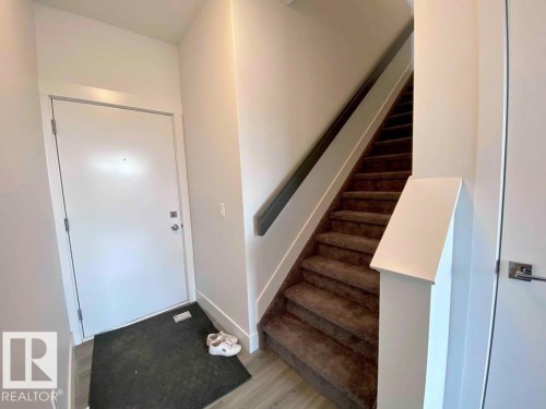 Foyer entrance with stairway and light wood-type flooring - 10 446 Allard Boulevard, Edmonton, AB - Indoor Photo Showing Other Room
