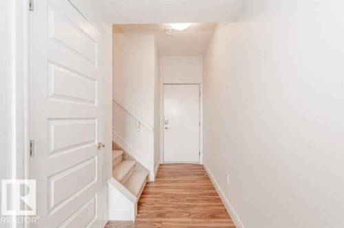 Corridor with light wood-type flooring and stairway - 10 446 Allard Boulevard, Edmonton, AB - Indoor Photo Showing Other Room