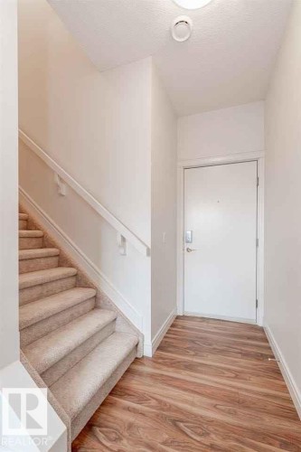 Stairway featuring wood finished floors and a textured ceiling - 10 446 Allard Boulevard, Edmonton, AB - Indoor Photo Showing Other Room