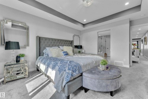 Bedroom featuring a raised ceiling, recessed lighting, carpet floors, and ensuite bath - 3607 46 Avenue, Beaumont, AB - Indoor Photo Showing Bedroom