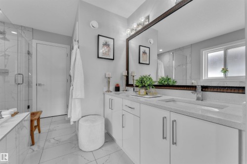 Bathroom featuring double vanity, a marble finish shower, and light marble finish floors - 3607 46 Avenue, Beaumont, AB - Indoor Photo Showing Bathroom