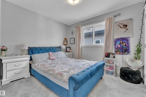 Bedroom with light colored carpet and a textured ceiling - 3607 46 Avenue, Beaumont, AB - Indoor Photo Showing Bedroom
