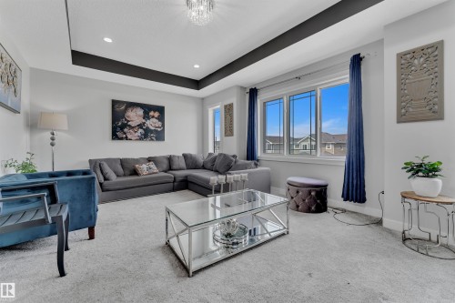 Living area featuring carpet, a tray ceiling, and recessed lighting - 3607 46 Avenue, Beaumont, AB - Indoor Photo Showing Living Room