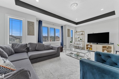 Carpeted living room featuring a tray ceiling and recessed lighting - 3607 46 Avenue, Beaumont, AB - Indoor Photo Showing Living Room