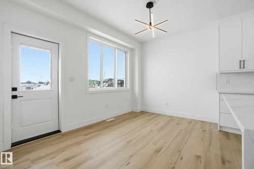 Unfurnished dining area featuring light wood-type flooring and baseboards - 2408 208 Street, Edmonton, AB - Indoor Photo Showing Other Room