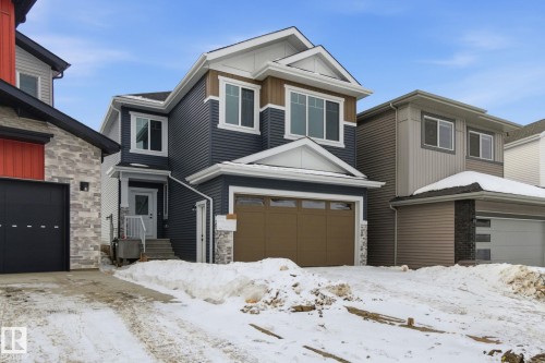 View of front of home with stone siding and a garage - 2408 208 Street, Edmonton, AB - Outdoor With Facade