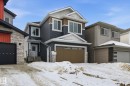 View of front of home with stone siding and a garage - 2408 208 Street, Edmonton, AB  - Outdoor With Facade 