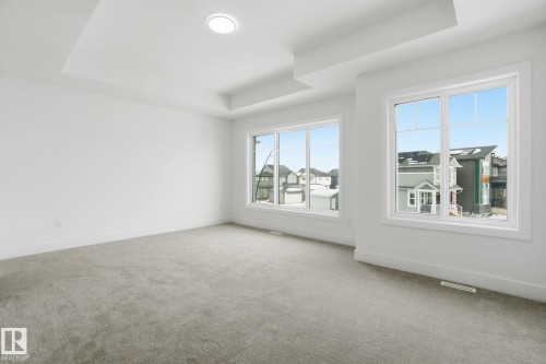 Empty room with a tray ceiling and light colored carpet - 2408 208 Street, Edmonton, AB - Indoor Photo Showing Other Room