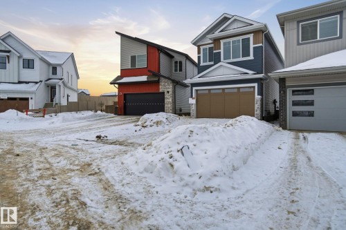 View of front of house with a garage and stone siding - 2408 208 Street, Edmonton, AB - Outdoor With Facade