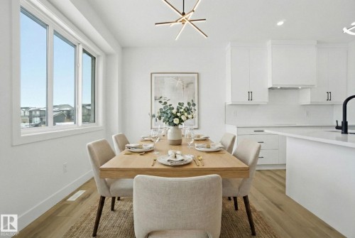 Dining space with light wood-style flooring and a chandelier - 2408 208 Street, Edmonton, AB - Indoor Photo Showing Dining Room
