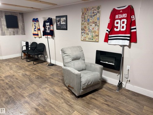 Sitting room with baseboards and dark wood finished floors - 4506 53 Avenue, Barrhead, AB - Indoor With Fireplace