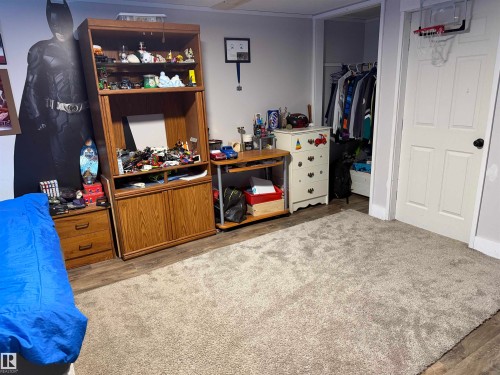 Bedroom with wood finished floors and a walk in closet - 4506 53 Avenue, Barrhead, AB - Indoor