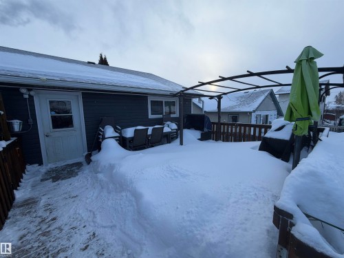 Yard covered in snow with a deck and a pergola - 4506 53 Avenue, Barrhead, AB - Outdoor