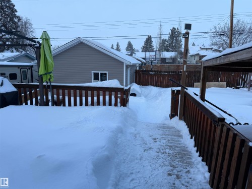 View of snowy exterior featuring a wooden deck - 4506 53 Avenue, Barrhead, AB - Outdoor With Deck Patio Veranda