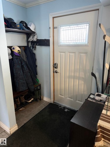 Mudroom with tile patterned floors and ornamental molding - 4506 53 Avenue, Barrhead, AB - Indoor Photo Showing Other Room