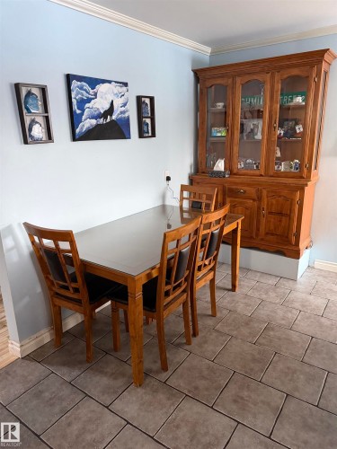 Dining room featuring ornamental molding and light tile patterned floors - 4506 53 Avenue, Barrhead, AB - Indoor Photo Showing Dining Room