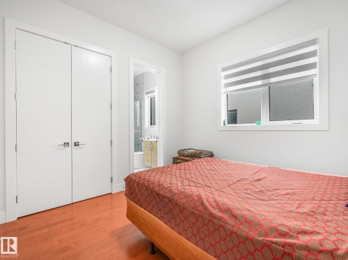 Bedroom with wood-type flooring, connected bathroom, and a closet - 120 38 Street, Edmonton, AB - Indoor Photo Showing Bedroom