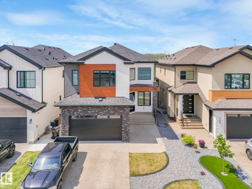 Contemporary home featuring a shingled roof, driveway, a residential view, a garage, and stucco siding - 120 38 Street, Edmonton, AB - Outdoor With Facade