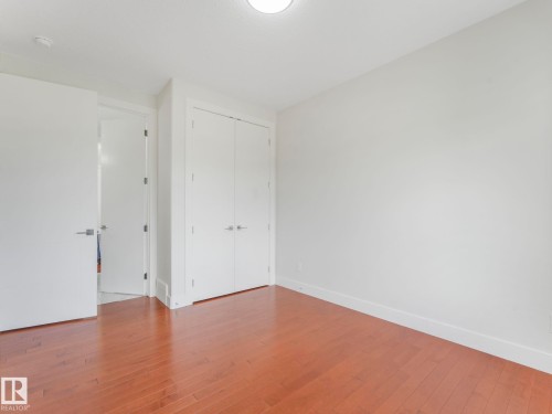Unfurnished bedroom with hardwood / wood-style flooring and a closet - 120 38 Street, Edmonton, AB - Indoor Photo Showing Other Room