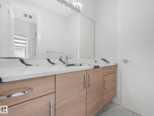 Bathroom featuring double vanity, light marble finish flooring, and a stall shower - 120 38 Street, Edmonton, AB - Indoor Photo Showing Bathroom