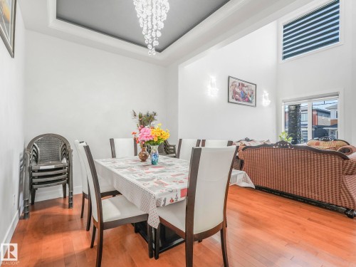 Dining space with wood-type flooring, hanging lights, and a tray ceiling - 120 38 Street, Edmonton, AB - Indoor Photo Showing Dining Room