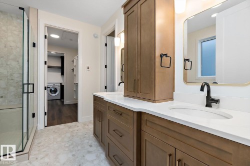 Full bath with vanity, a stall shower, washer / clothes dryer, and a spacious closet - 128 Lilac Close, Leduc, AB 