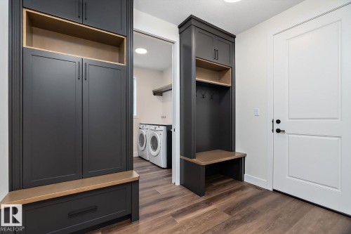 Mudroom with dark wood-style flooring and washer and clothes dryer - 128 Lilac Close, Leduc, AB 