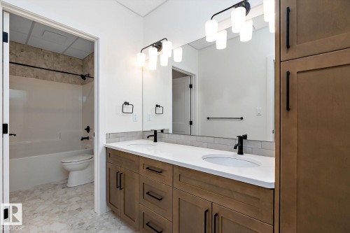 Bathroom featuring double vanity and shower / tub combination - 128 Lilac Close, Leduc, AB 