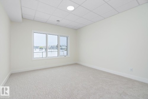 Spare room featuring a paneled ceiling and light colored carpet - 128 Lilac Close, Leduc, AB 