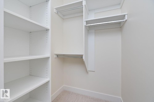 Walk in closet with light carpet - 128 Lilac Close, Leduc, AB 