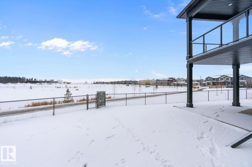 Yard layered in snow with a residential view - 128 Lilac Close, Leduc, AB 