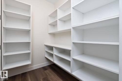 Walk in closet with dark wood-type flooring - 128 Lilac Close, Leduc, AB 